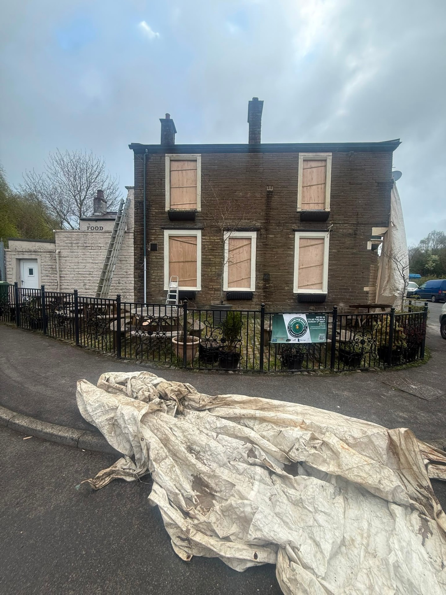 Before — boarded up, blackened stone