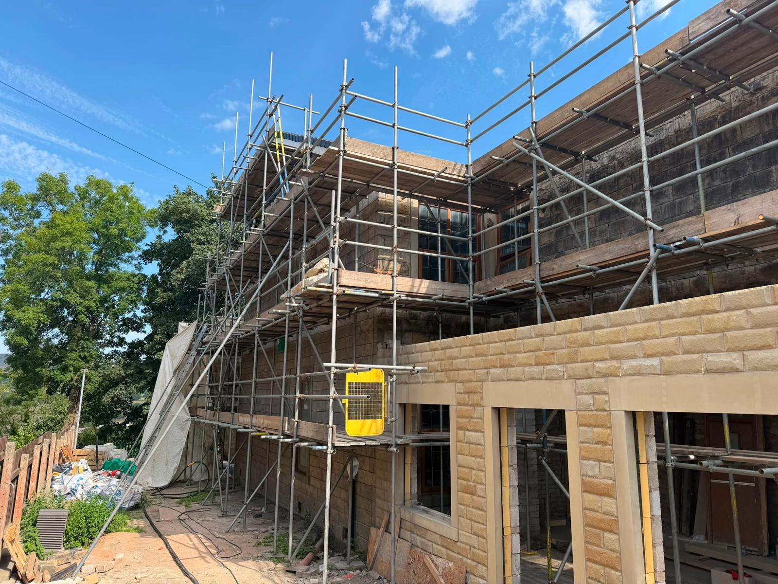 Scaffolded stone frontage part-cleaned — soot stripped back to sandstone